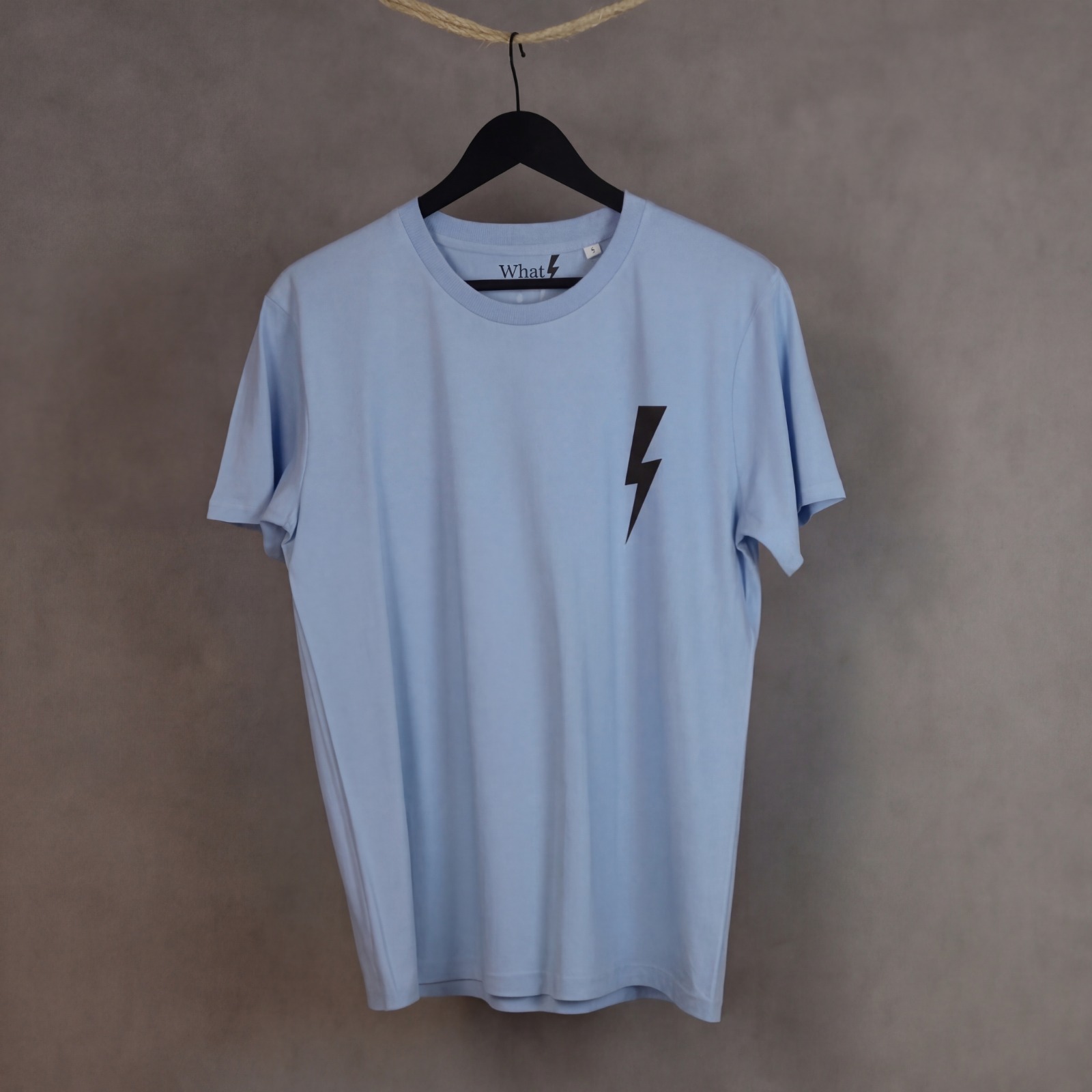 Detalle frontal de la camiseta Leader de WhatStyle en algodón orgánico con logotipo oficial y rayo.