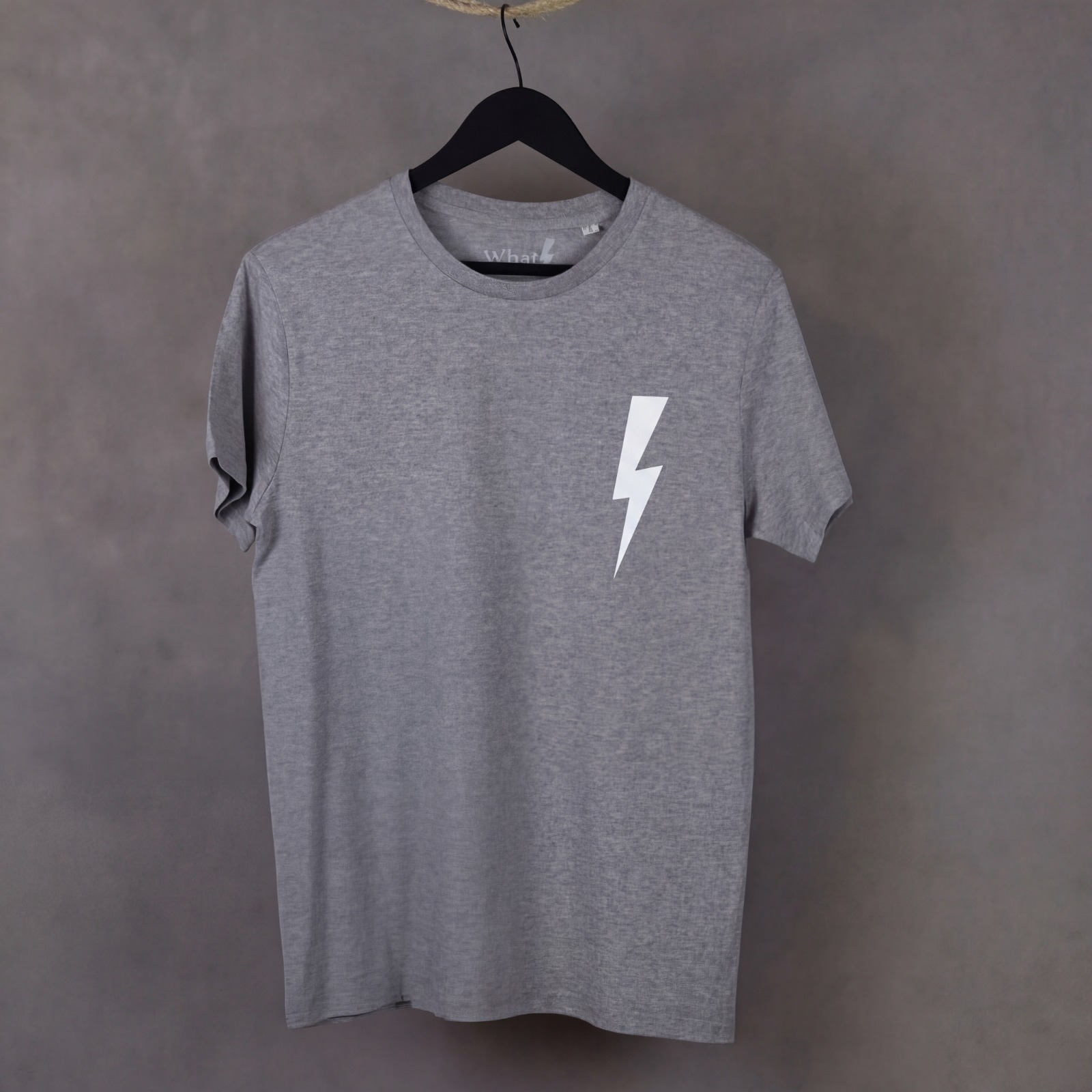 Detalle frontal de la camiseta Leader de WhatStyle en algodón orgánico con logotipo oficial y rayo.